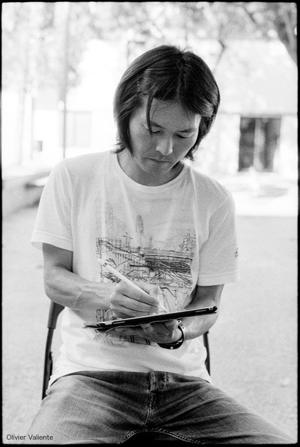 Photo of Takayuki Maejima, taken by Olivier Valiente, drawing Olivier's portrait in profile.